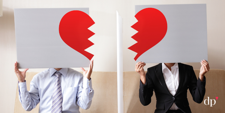 Two people each holding a sign with one half of a broken heart