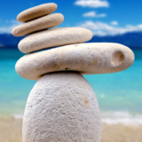 Zen rocks stack on beautiful beach to represent self-care