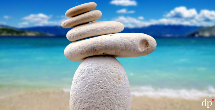 Zen rocks stack on beautiful beach to represent self-care