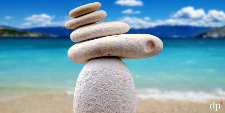 Zen rocks stack on beautiful beach to represent self-care