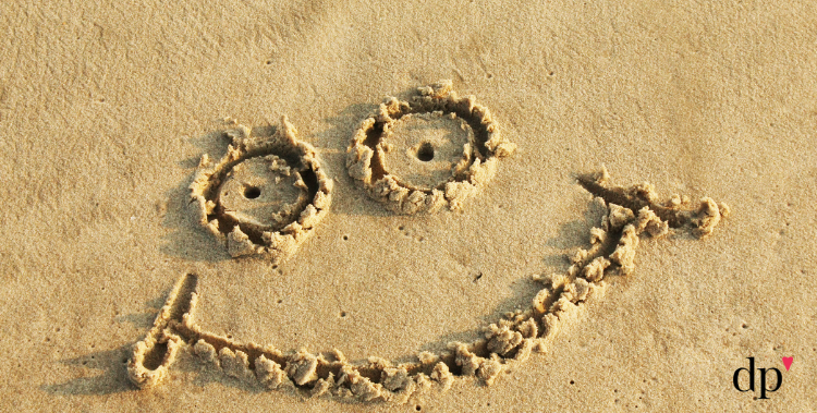 Smiley face written in sand