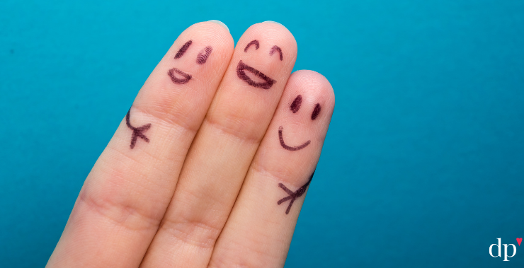 fingers with smiles penned on them, embracing each other