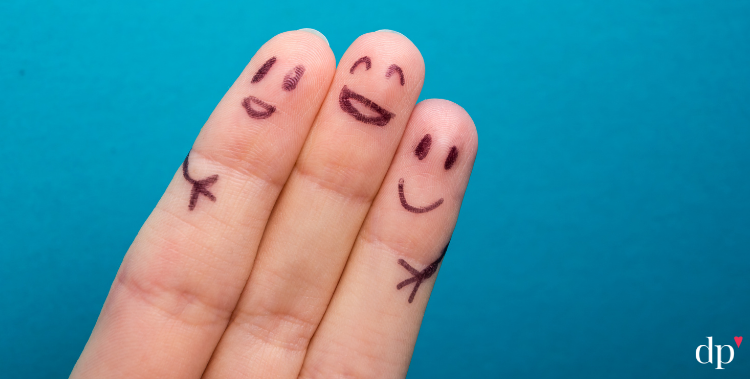 fingers with smiles penned on them, embracing each other